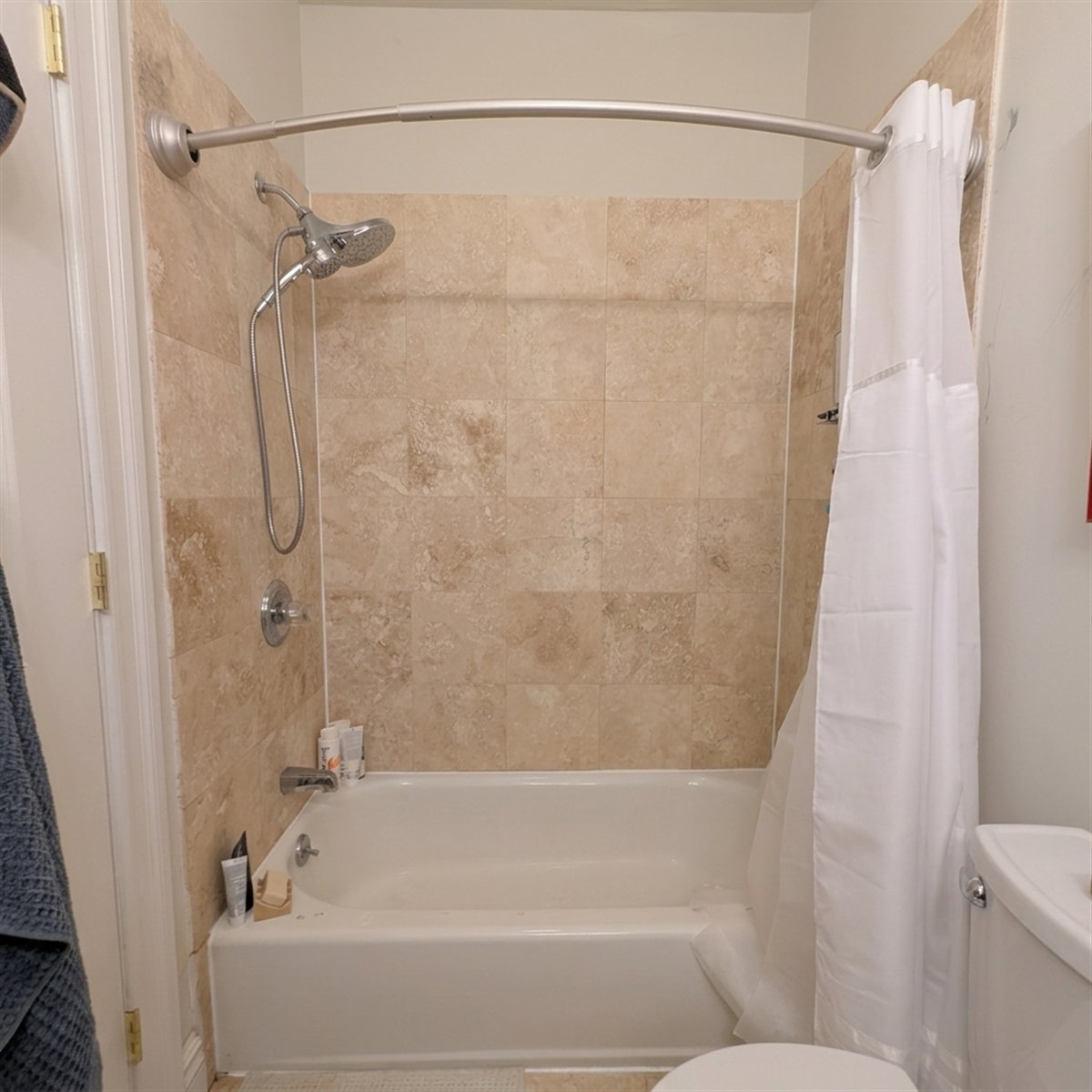 Bathroom No. 3 — existing bathtub and beige tile wall before renovation